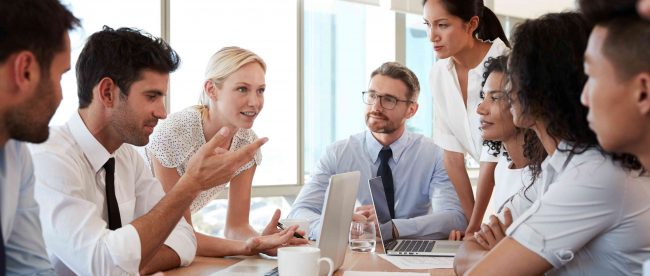 Group Of Businesspeople Meeting Around Table In Office