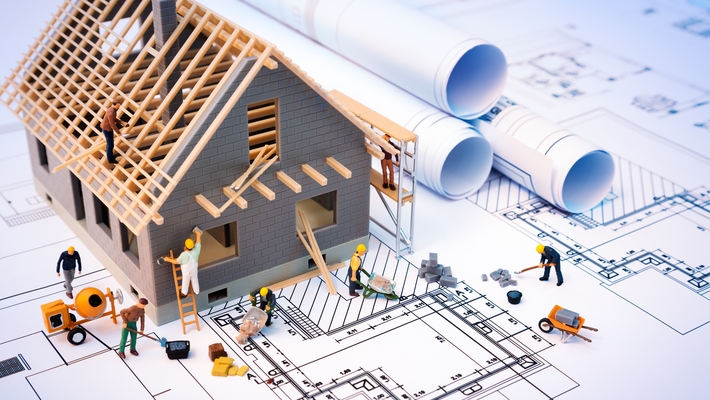 building house on blueprints with worker – construction project